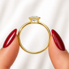 Side profile of an emerald-cut lab-grown diamond bezel-set solitaire engagement ring in yellow gold