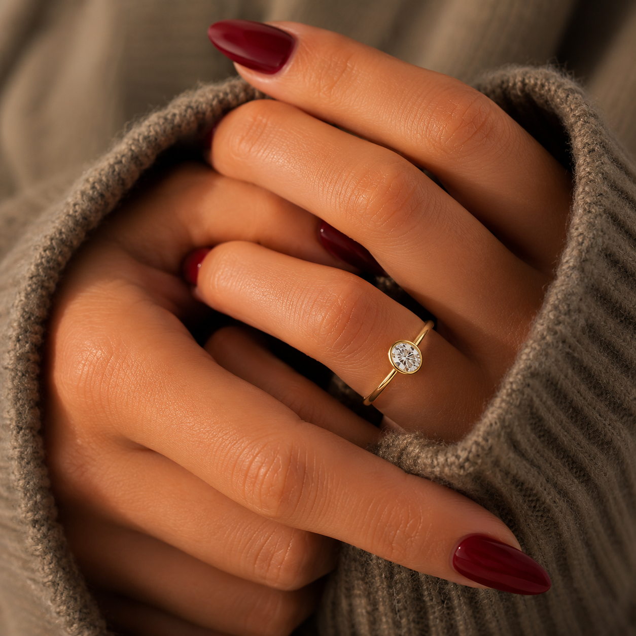 Oval-cut lab-grown diamond bezel-set solitaire engagement ring lifestyle close-up