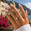 Oval-cut lab-grown diamond bezel-set solitaire engagement ring worn on hand