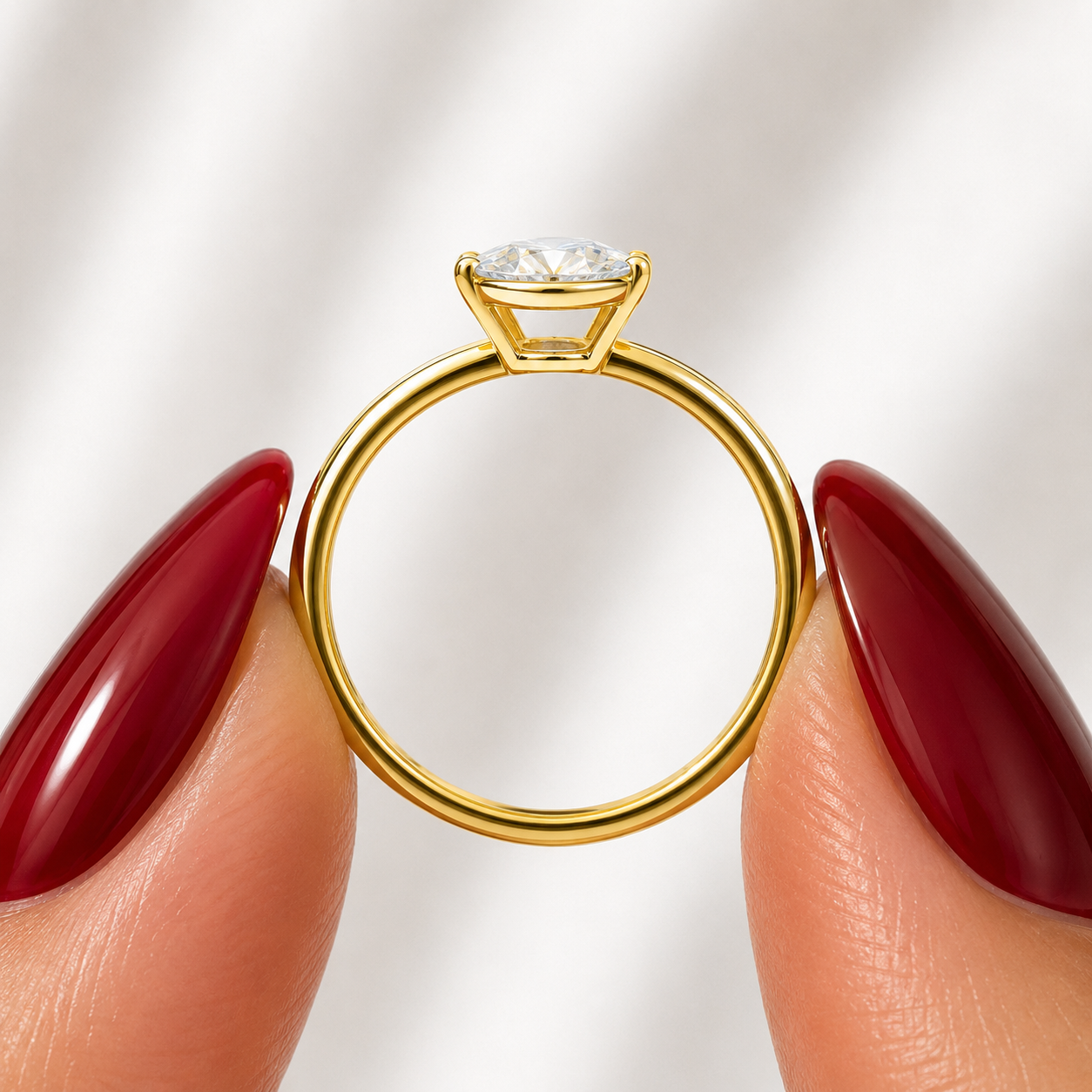 Side profile of an oval-cut lab-grown diamond bezel-set solitaire engagement ring in yellow gold