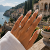 Oval-cut lab-grown diamond cathedral solitaire engagement ring worn on hand