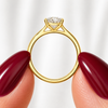 Side profile of an oval-cut lab-grown diamond cathedral solitaire engagement ring in yellow gold