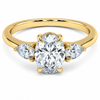 Front view of an oval-cut lab-grown diamond trilogy engagement ring in yellow gold