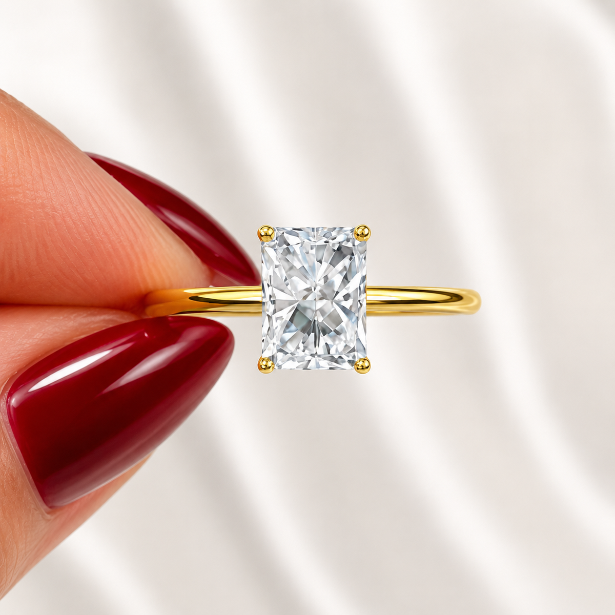 Close-up of a radiant-cut lab-grown diamond solitaire engagement ring in yellow gold