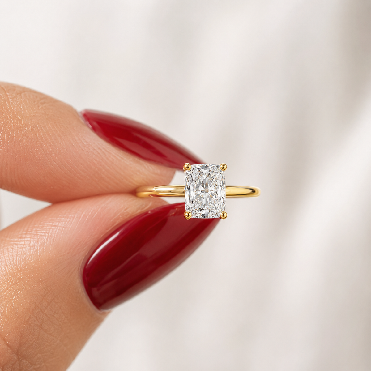 Close-up of an elongated cushion-cut lab-grown diamond solitaire engagement ring in yellow gold