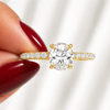 Close-up of an oval-cut lab-grown diamond hidden halo pavé engagement ring in yellow gold