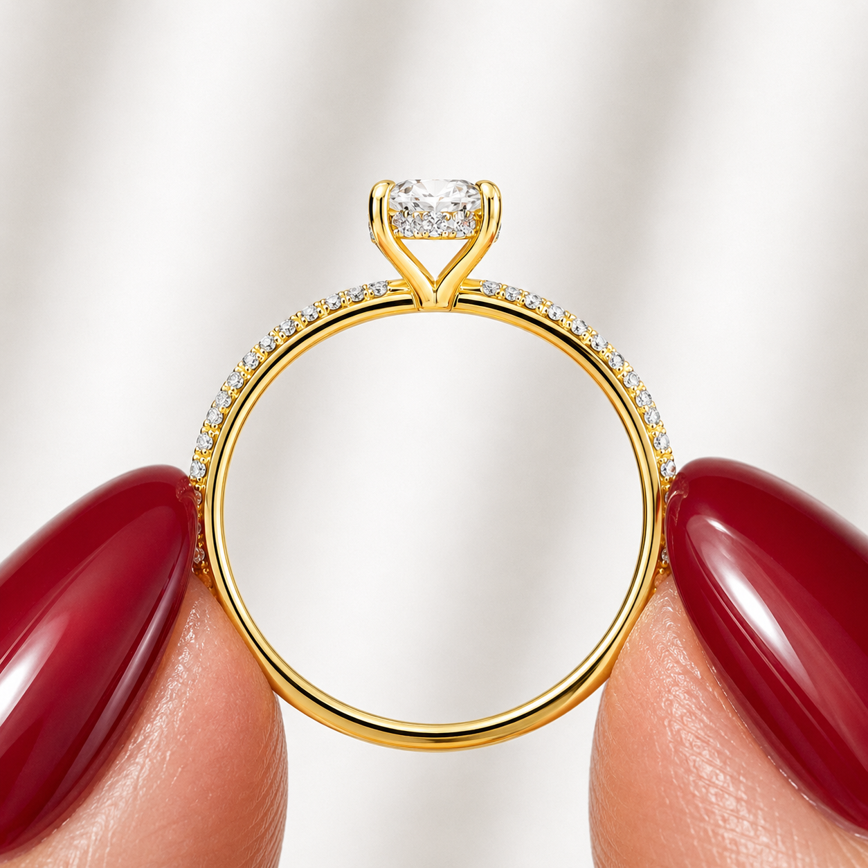 Side profile of an oval-cut lab-grown diamond hidden halo pavé engagement ring in yellow gold