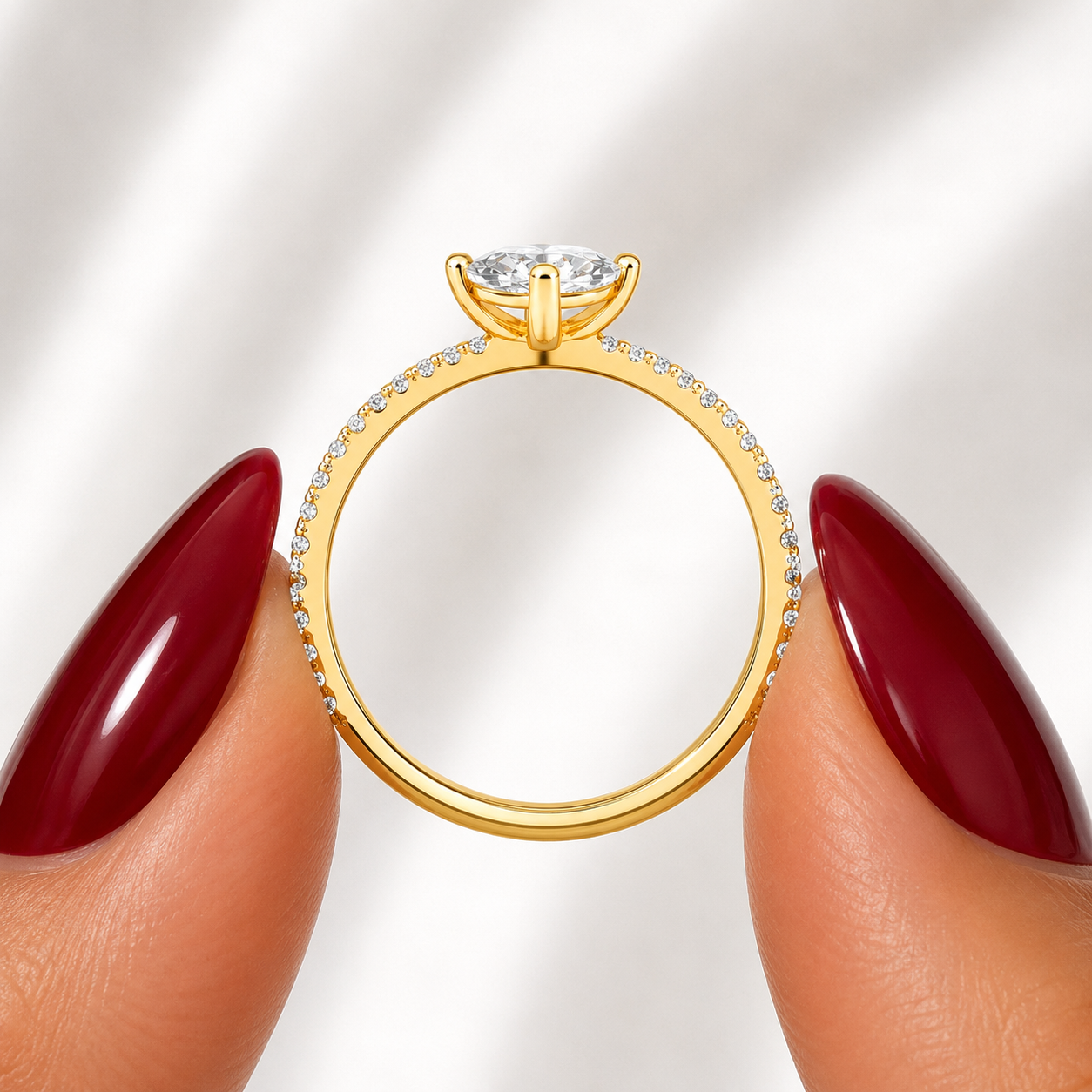 Side profile of an oval-cut lab-grown diamond pavé solitaire engagement ring in yellow gold