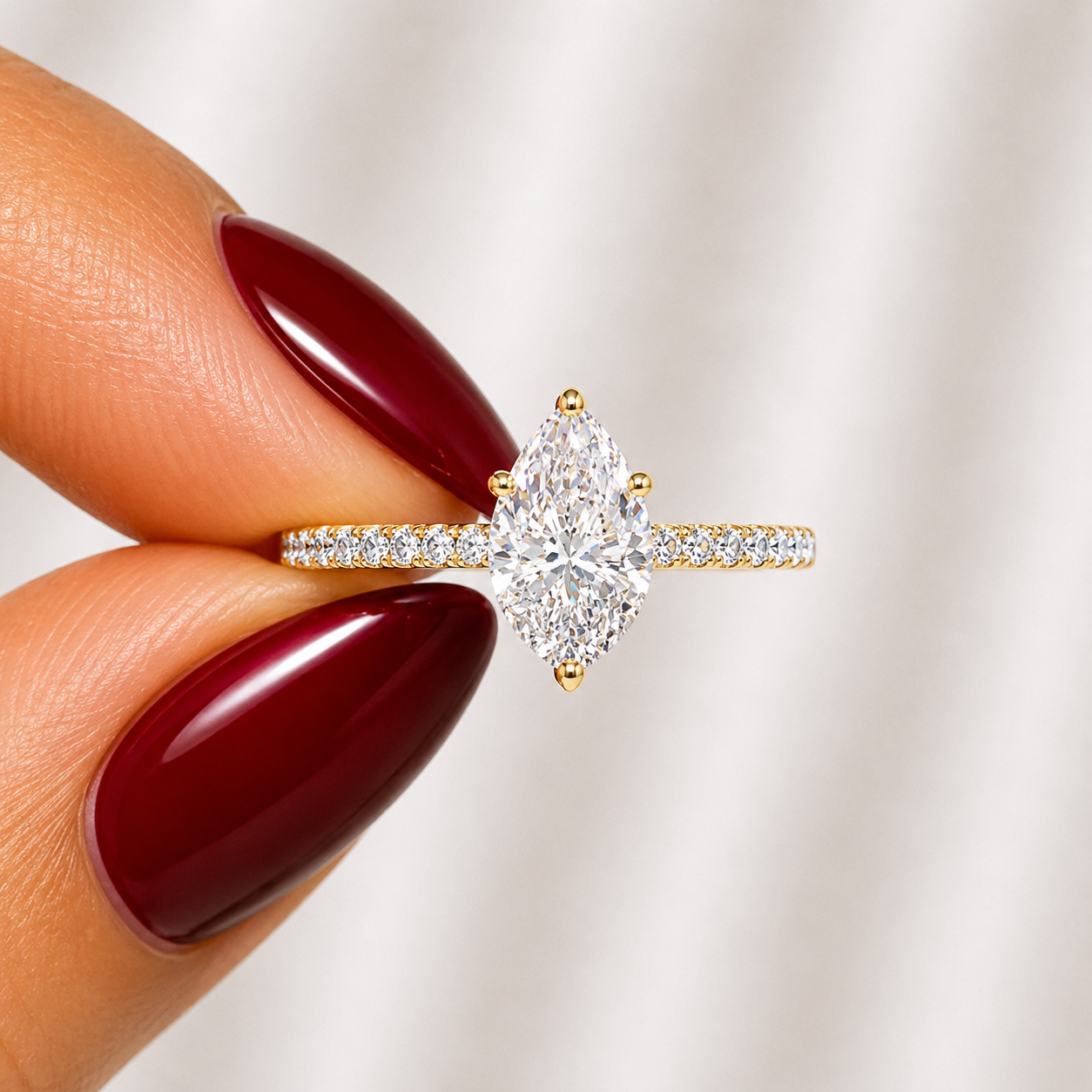 Close-up of a pear-cut lab-grown diamond pavé solitaire engagement ring in yellow gold