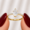 Side profile of a pear-cut lab-grown diamond pavé solitaire engagement ring in yellow gold