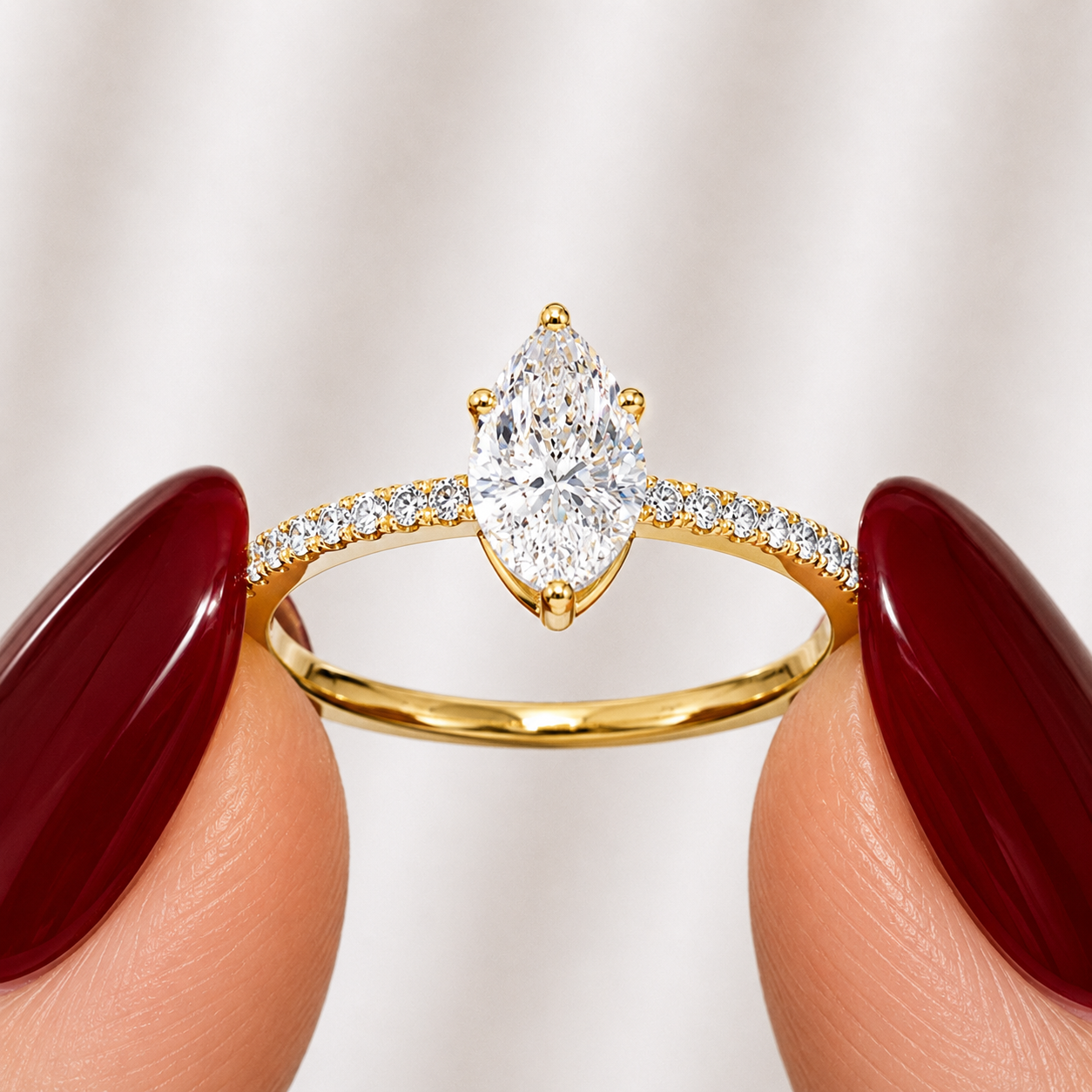 Side profile of a pear-cut lab-grown diamond pavé solitaire engagement ring in yellow gold