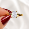 Close-up of a radiant-cut lab-grown diamond hidden halo engagement ring in yellow gold