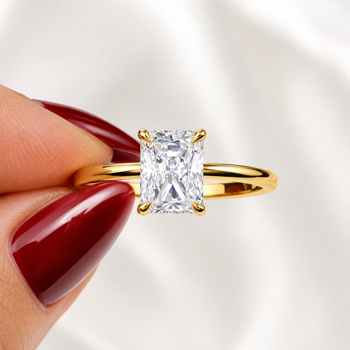 Close-up of a radiant-cut lab-grown diamond hidden halo engagement ring in yellow gold